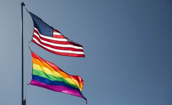 U.S. Flag and Pride flag flying. 