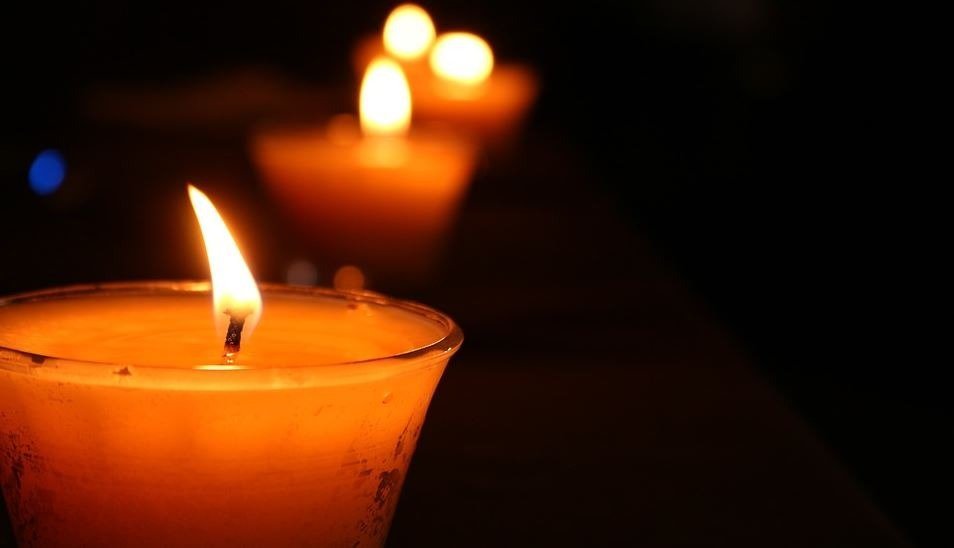 Photo of lit candles in dark.